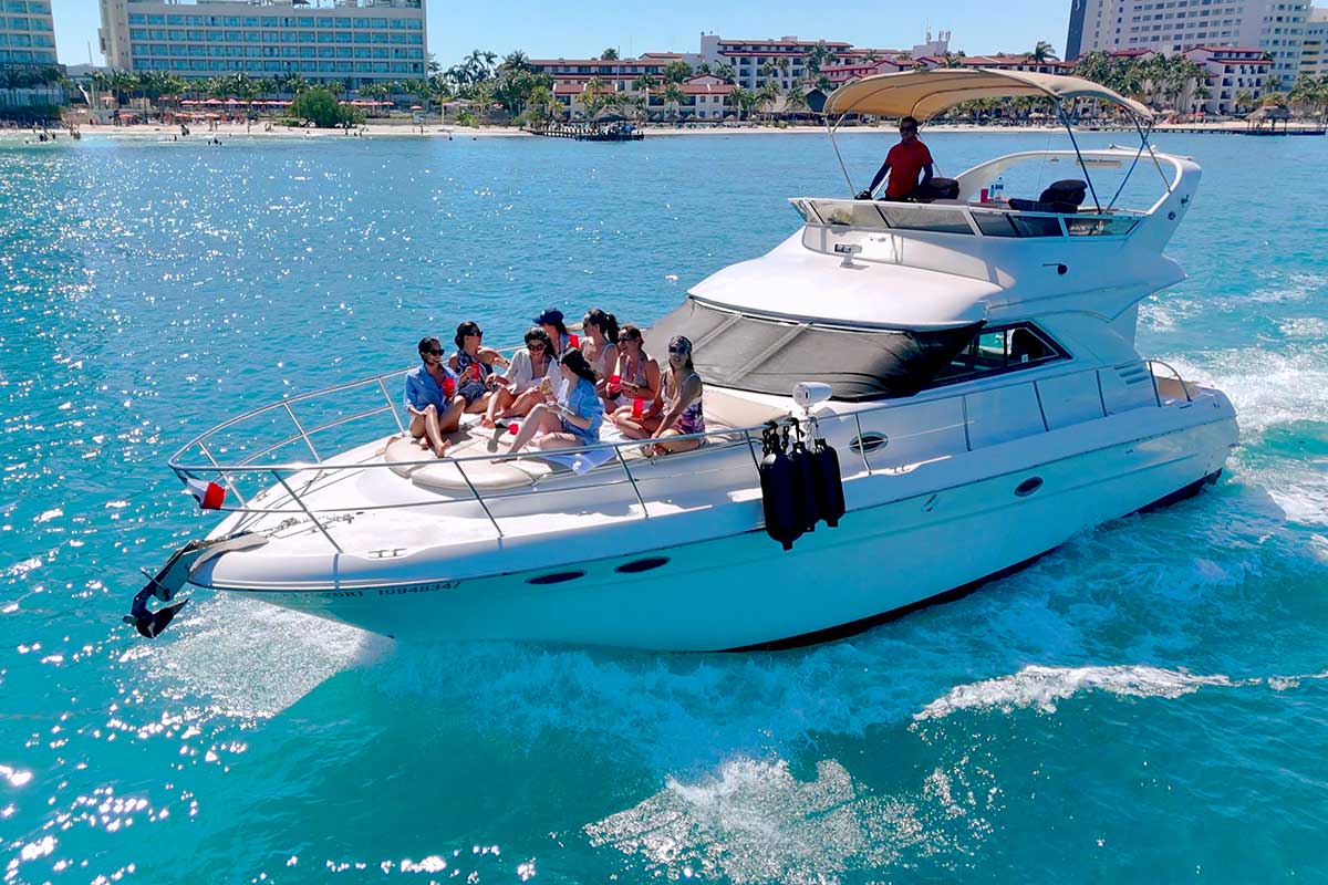 Grupo de personas disfrutando en un yate familiar en Cancún con vista al mar.