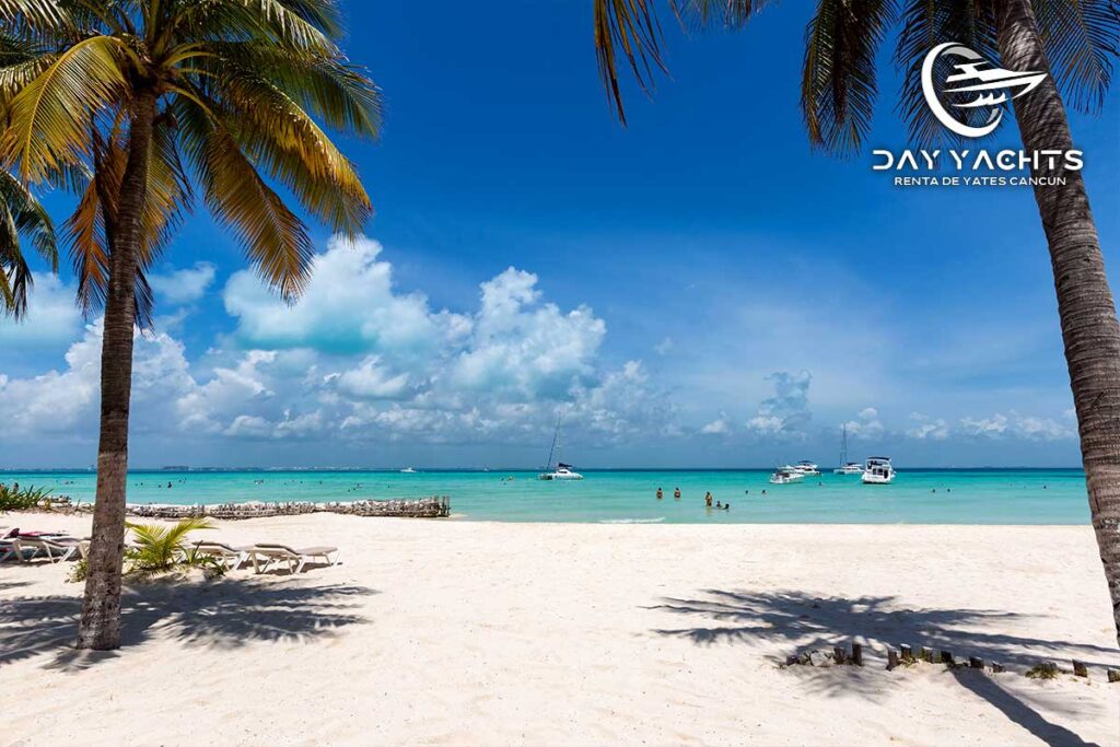 Yate de lujo anclado en Playa Norte Isla Mujeres con aguas turquesa.